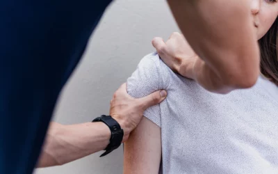 Physical therapist assessing shoulder mobility in patient during physical therapy evaluation at True Health and Performance.