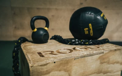 Kettlebell and medicine ball on a wooden box, emphasizing strength training and fitness equipment for physical therapy and personal training.